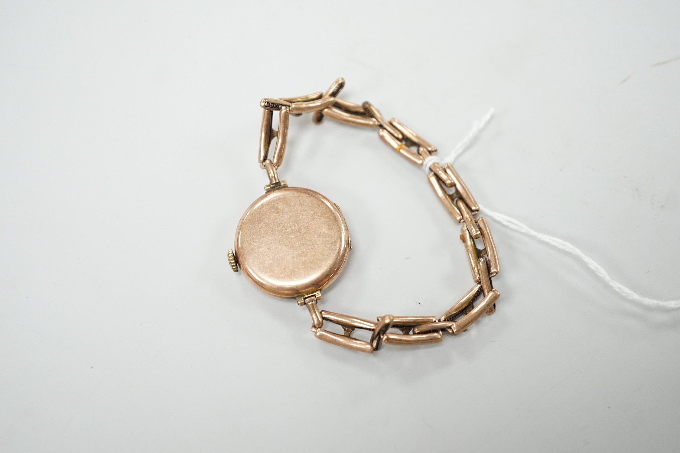 An early 20th century 9ct gold Rolex manual wind wrist watch, with Arabic dial, case diameter 27mm, on an expanding yellow metal bracelet, gross weight 22.1 grams.